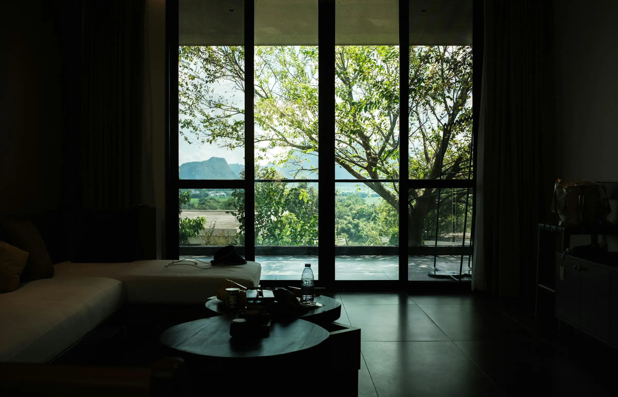 A living room opening onto a planted garden through full-height glass